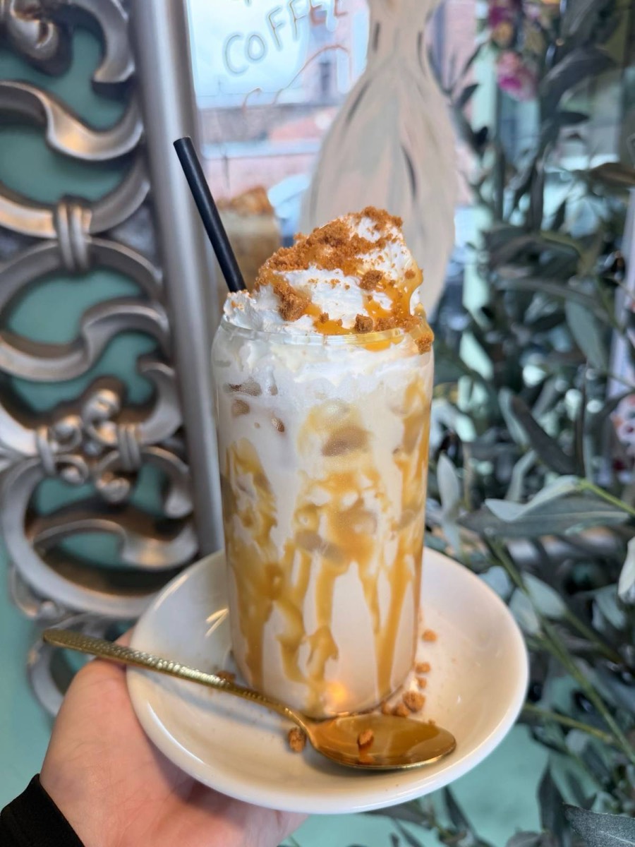 Iced coffee topped with cream and biscuit crumb